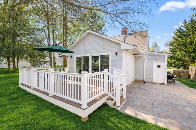 Rear home addition with outdoor deck living space and open patio.